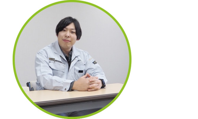 机に座りこちらを向いて微笑む土木部の熊﨑さん